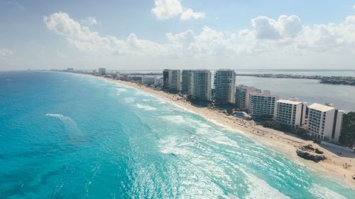 A breathtaking aerial view of Cancun's pristine beaches and luxury beachfront resorts under a sunny sky.